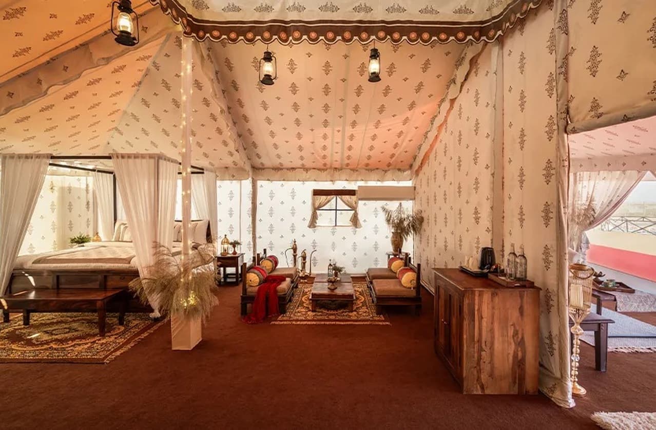 Rajwadi Suite tent interior with living area and bedroom under patterned canopy at Rann Utsav Tent City