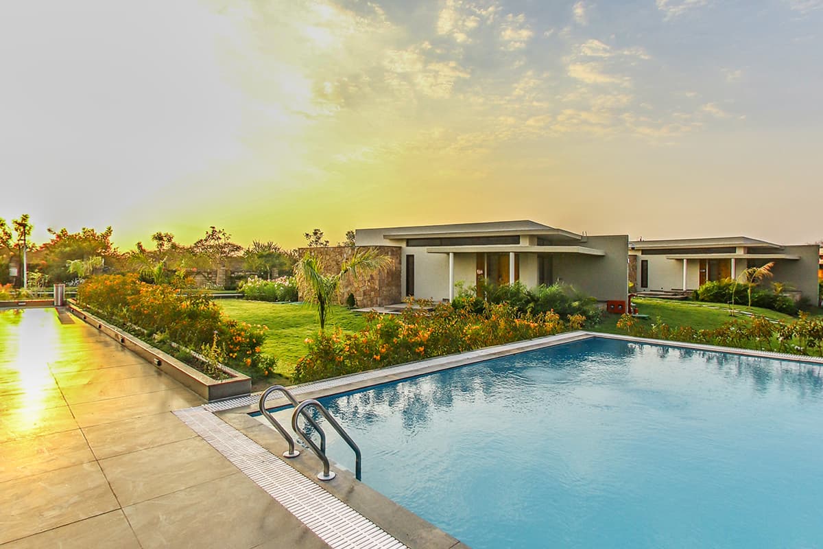 Swimming pool with garden villas at Araiya Gir resort, Sasan Gir