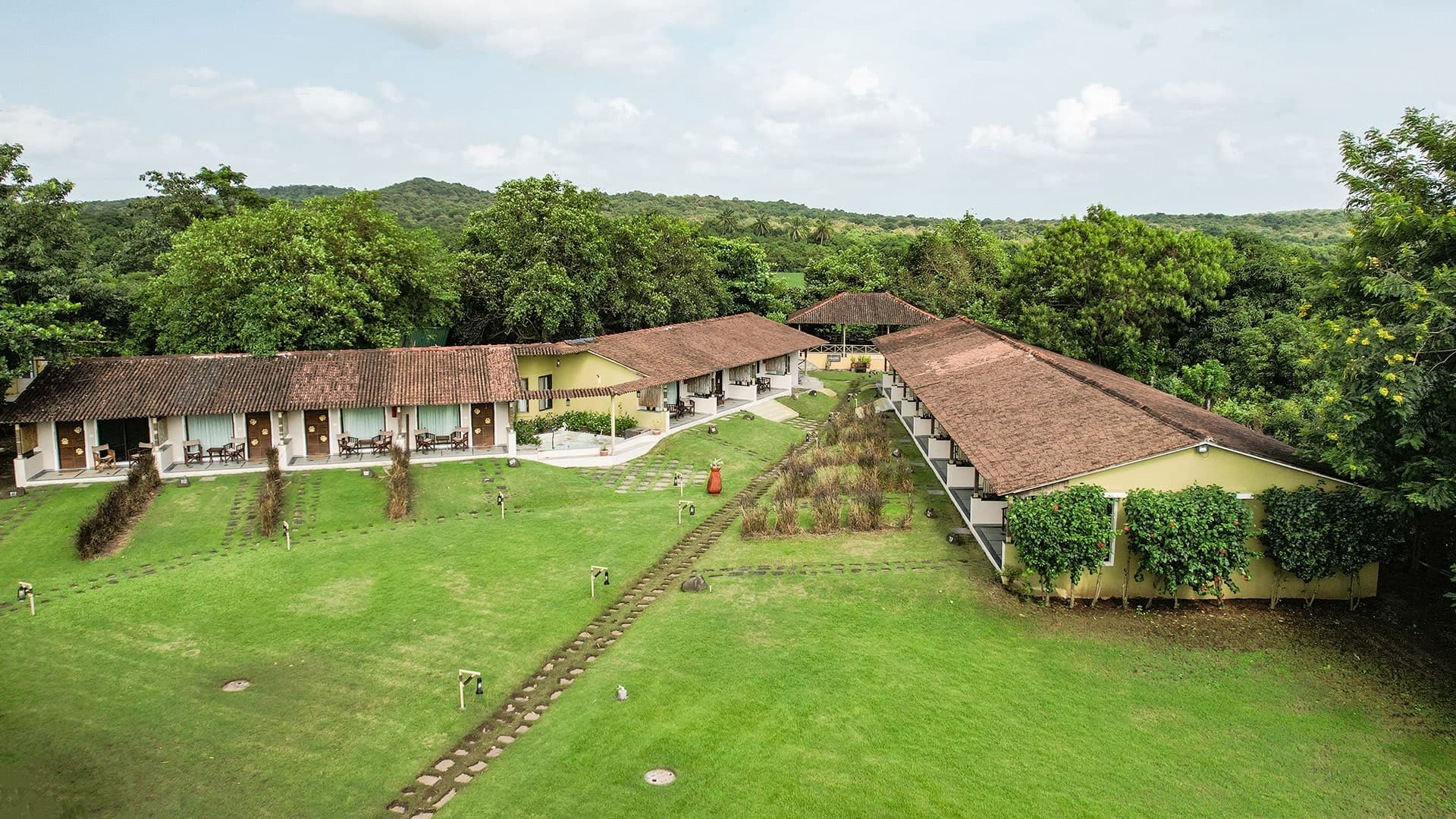 Aerial view of Asiatic Lion Lodge cottages and lawns among the Gir forest hills