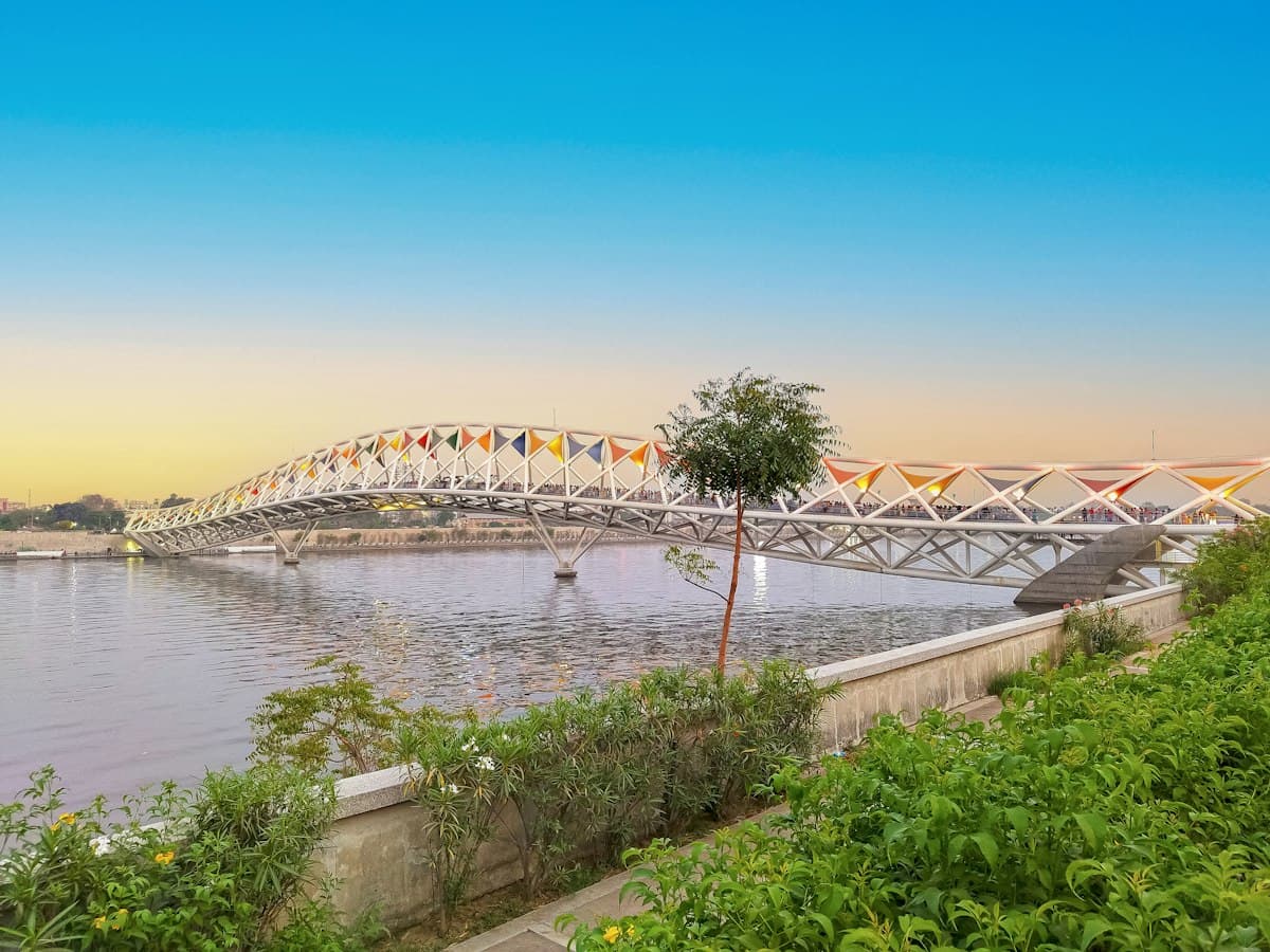 Sabarmati Riverfront and the Atal Pedestrian Bridge in Ahmedabad at dusk under a fading blue-to-orange sky
