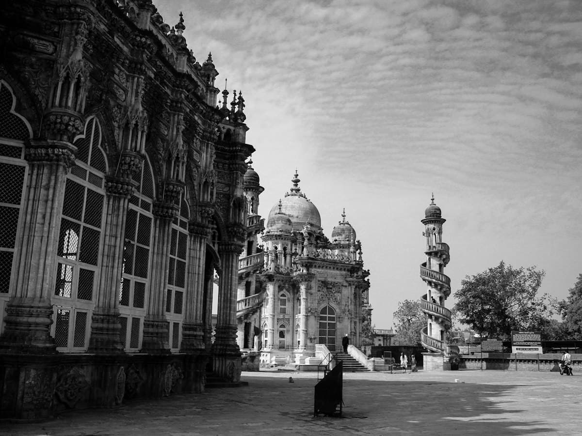 Black-and-white view of the ornate Mahabat Maqbara mausoleum and its spiral minaret in Junagadh, Gujarat