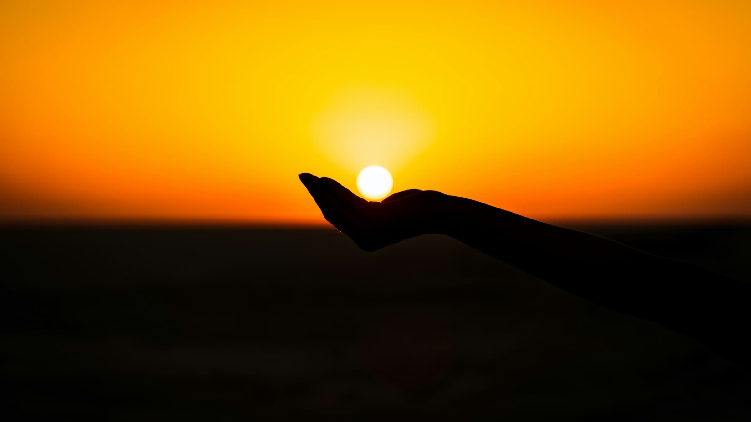 The sun cradled in an outstretched hand as it sets over the Rann of Kutch, Gujarat, in silhouette