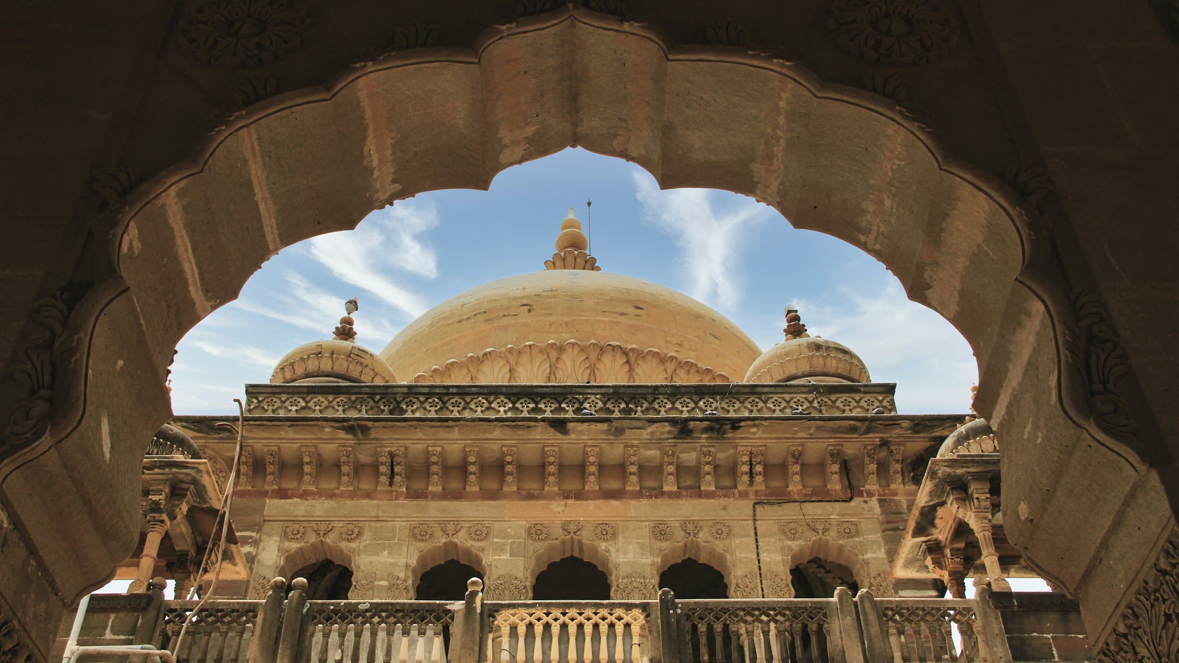 The domed Vijay Vilas Palace at Mandvi in Kutch framed by a carved sandstone arch, Gujarat