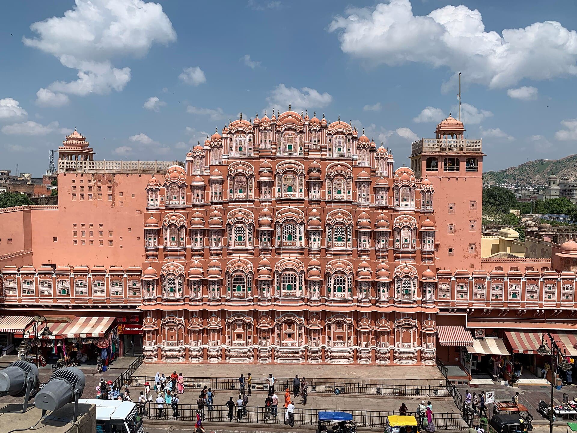 The pink sandstone east facade of Hawa Mahal rising above the street in Jaipur