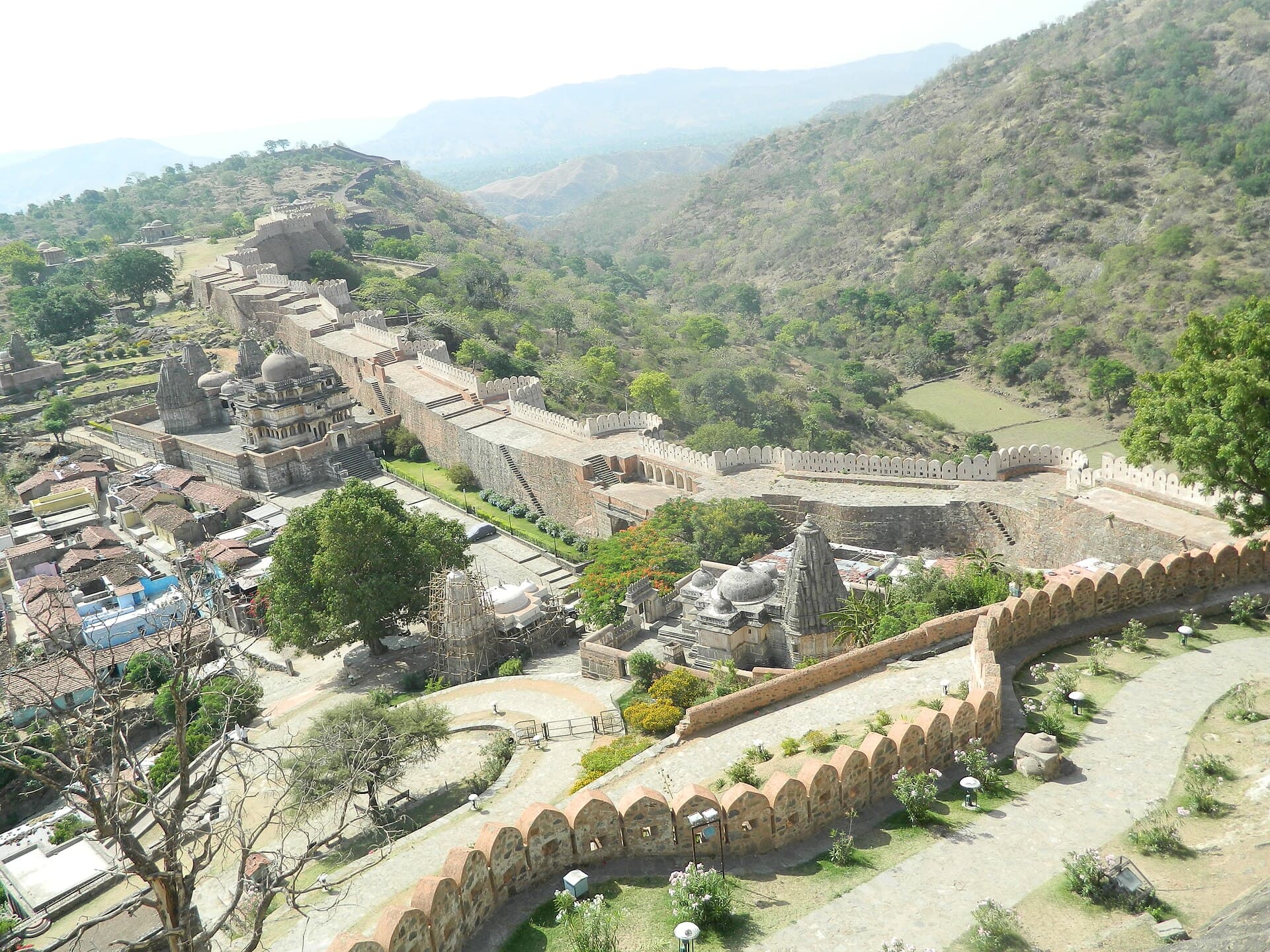 The wall of Kumbhalgarh Fort running above a village and the valley
