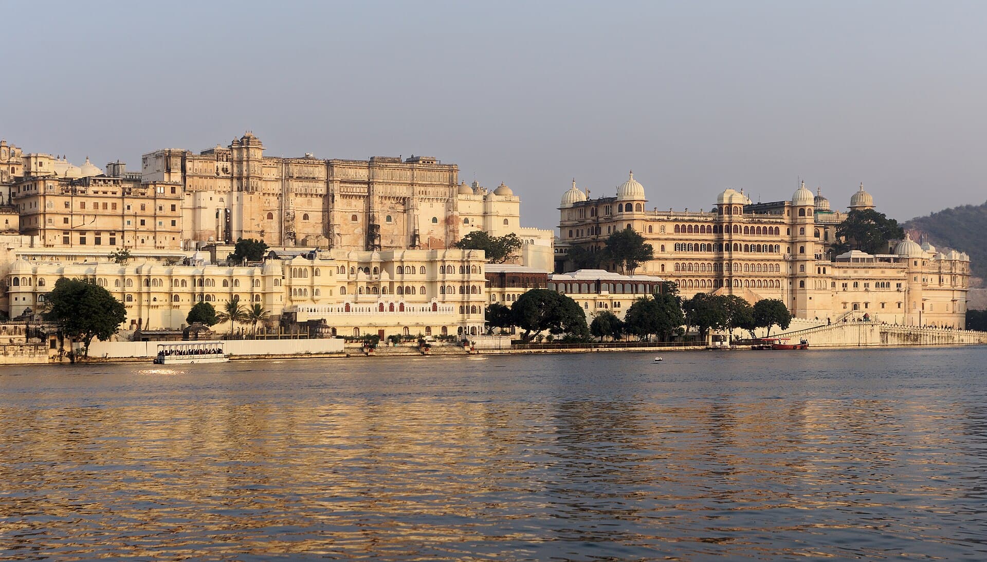 The City Palace of Udaipur lit gold across the water of Lake Pichola