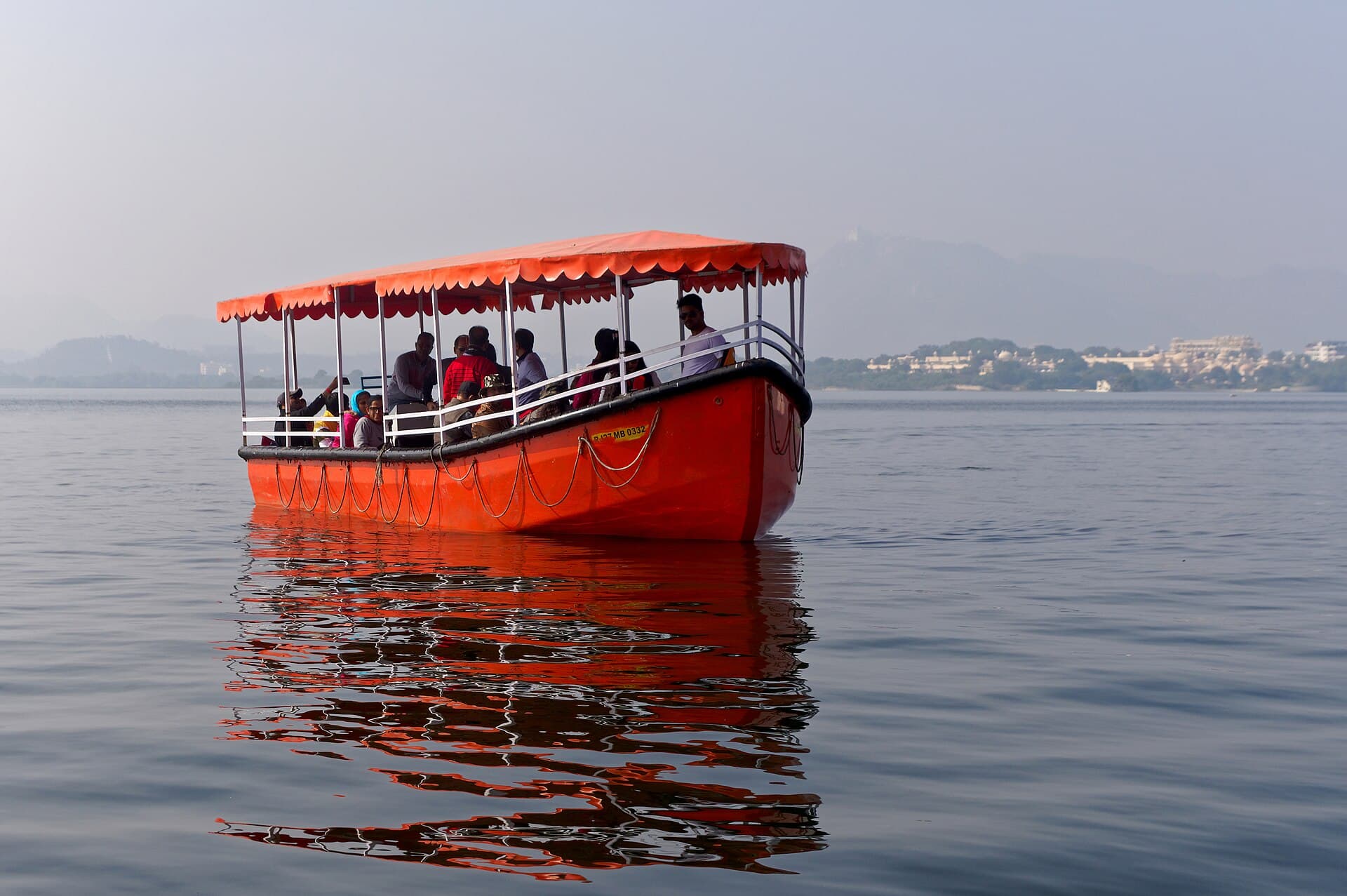 A red covered tourist boat on Lake Pichola in Udaipur