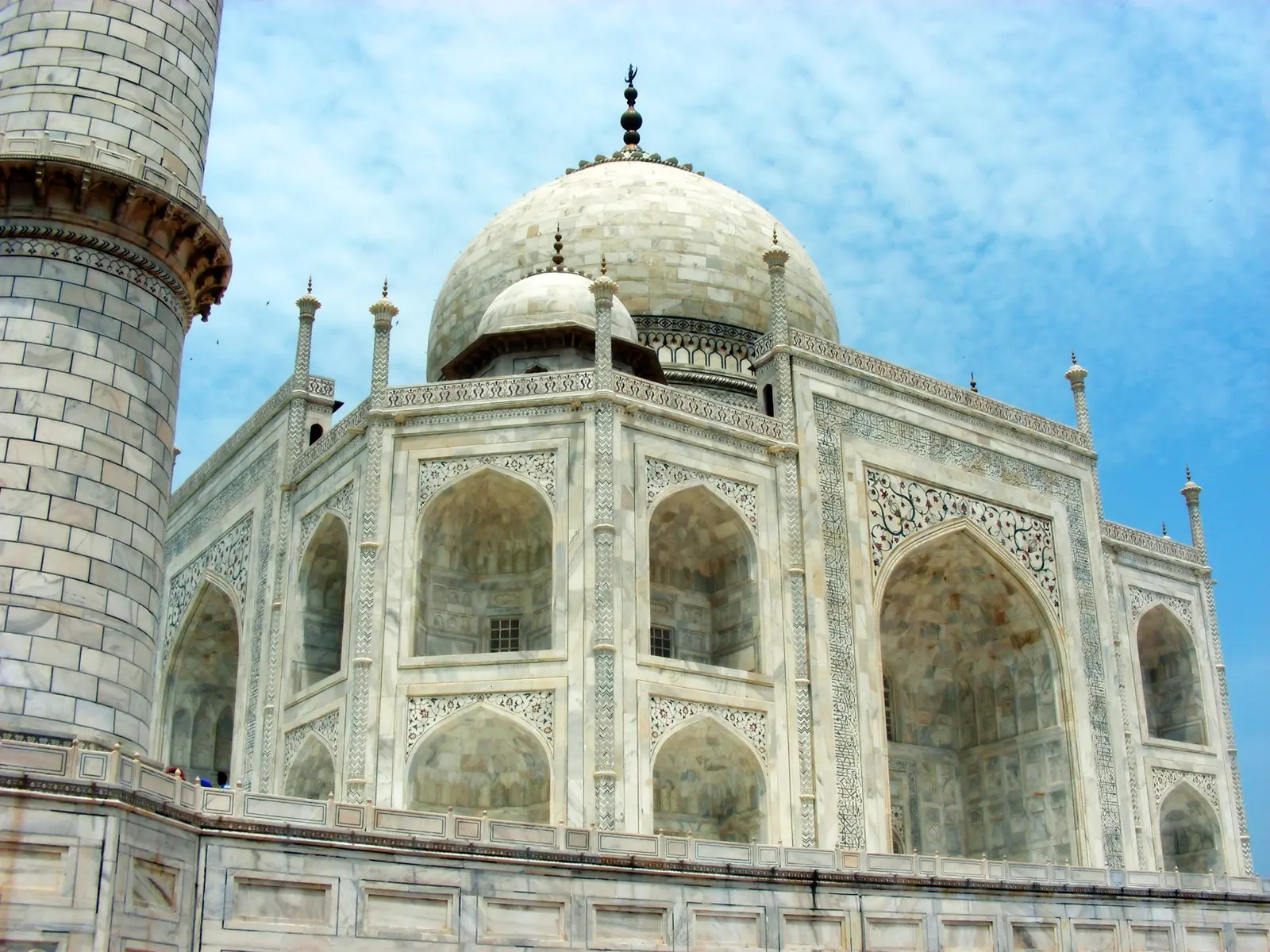 A corner of the Taj Mahal tomb showing a minaret and arched marble walls