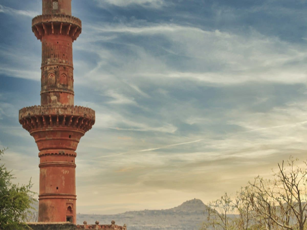 The Chand Minar tower rising against a cloudy sky inside Daulatabad Fort, Maharashtra