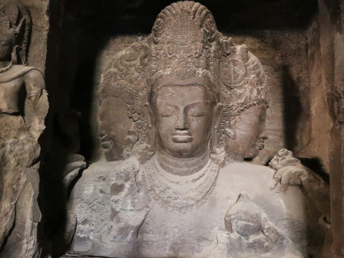 A carved stone figure of a deity inside a cave at Elephanta, Maharashtra