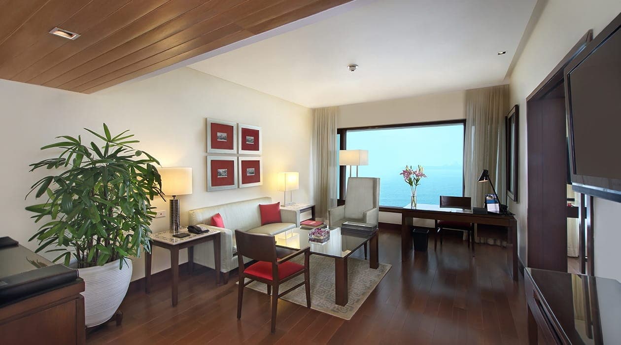 Ocean view suite living room with dining table and sea-facing window at The Oberoi, Mumbai