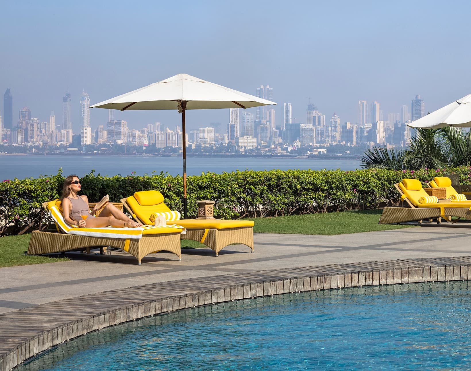 Sun loungers by the pool terrace with the Mumbai skyline behind at Trident, Nariman Point