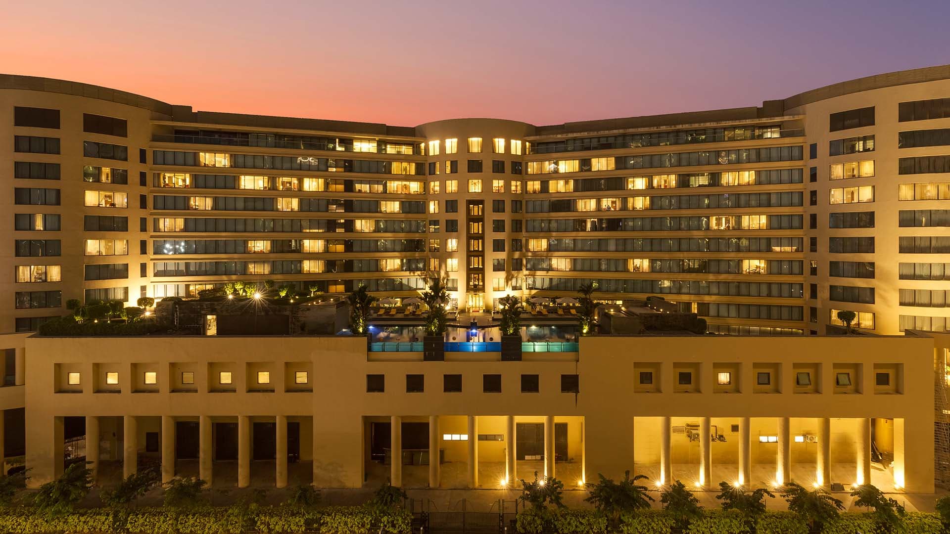 Trident, Bandra Kurla curved facade lit at dusk beside the pool terrace