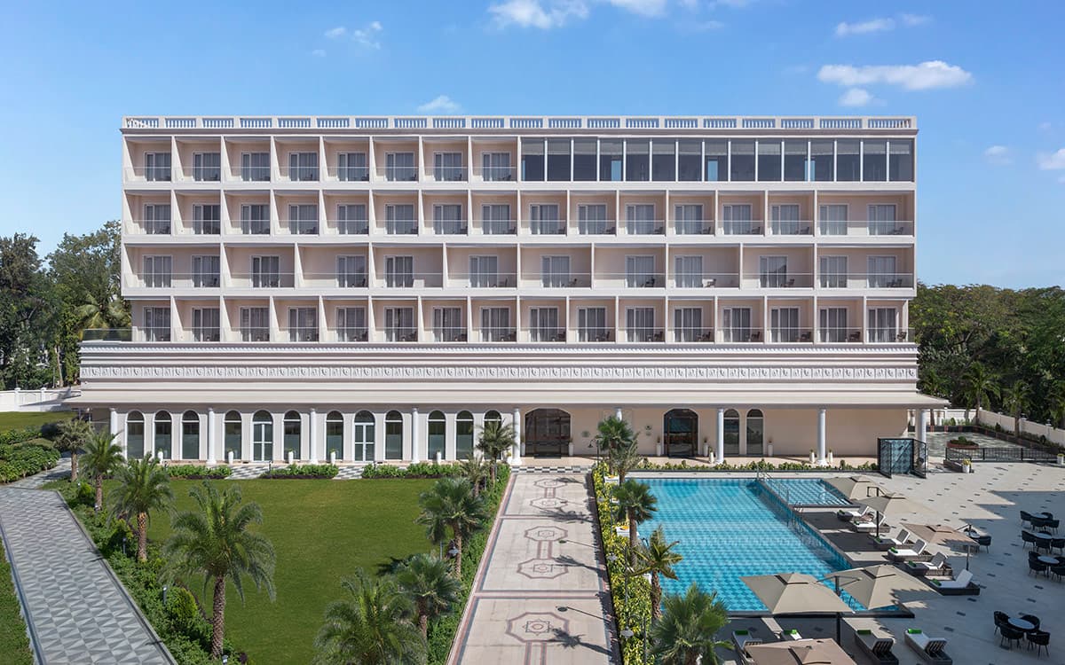 Welcomhotel Rama International facade by day with the pool and lawns in Aurangabad
