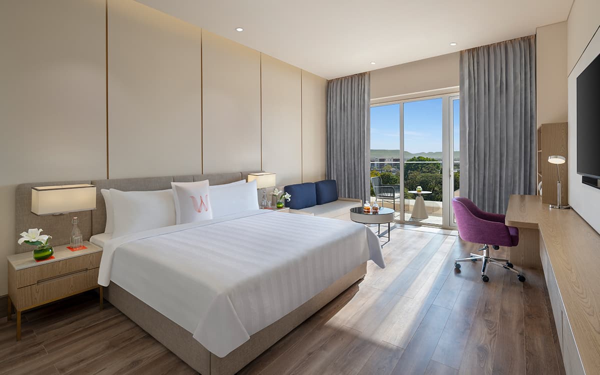 Executive Club Exclusive room with king bed, work desk and balcony doors at Welcomhotel Rama International