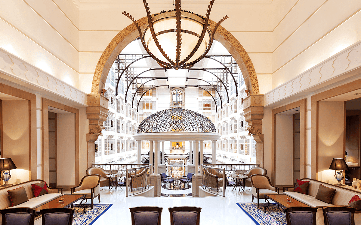 Residents' lounge under a grand arch looking onto the garden atrium at ITC Maratha, Mumbai