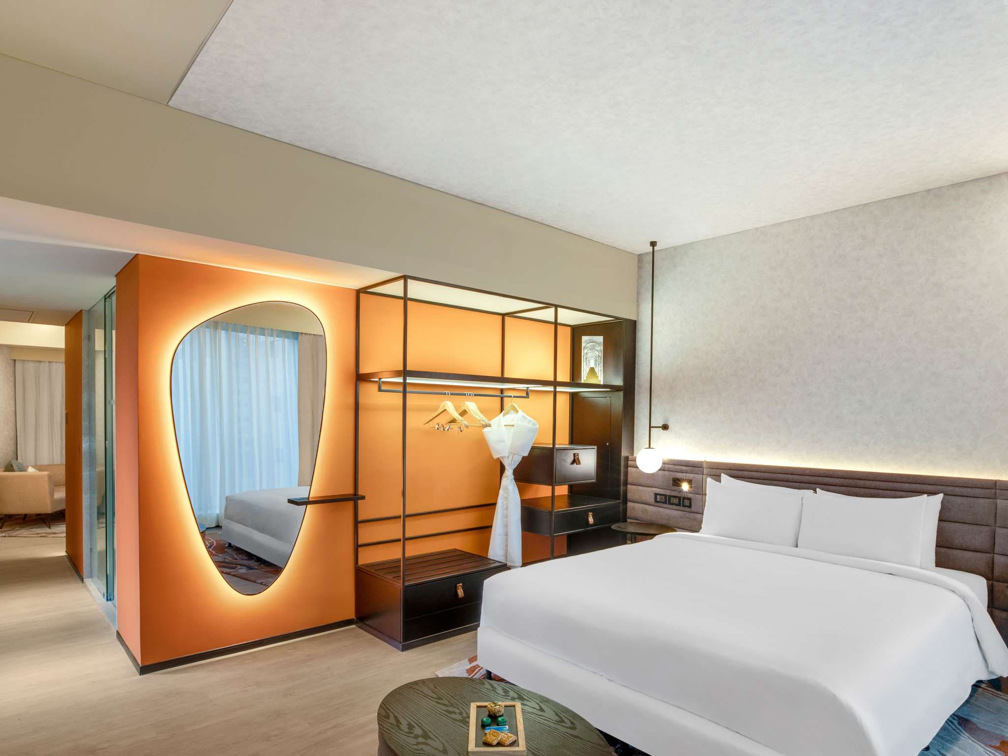 Premier Suite bedroom with an illuminated mirror and king bed at Novotel Pune Nagar Road