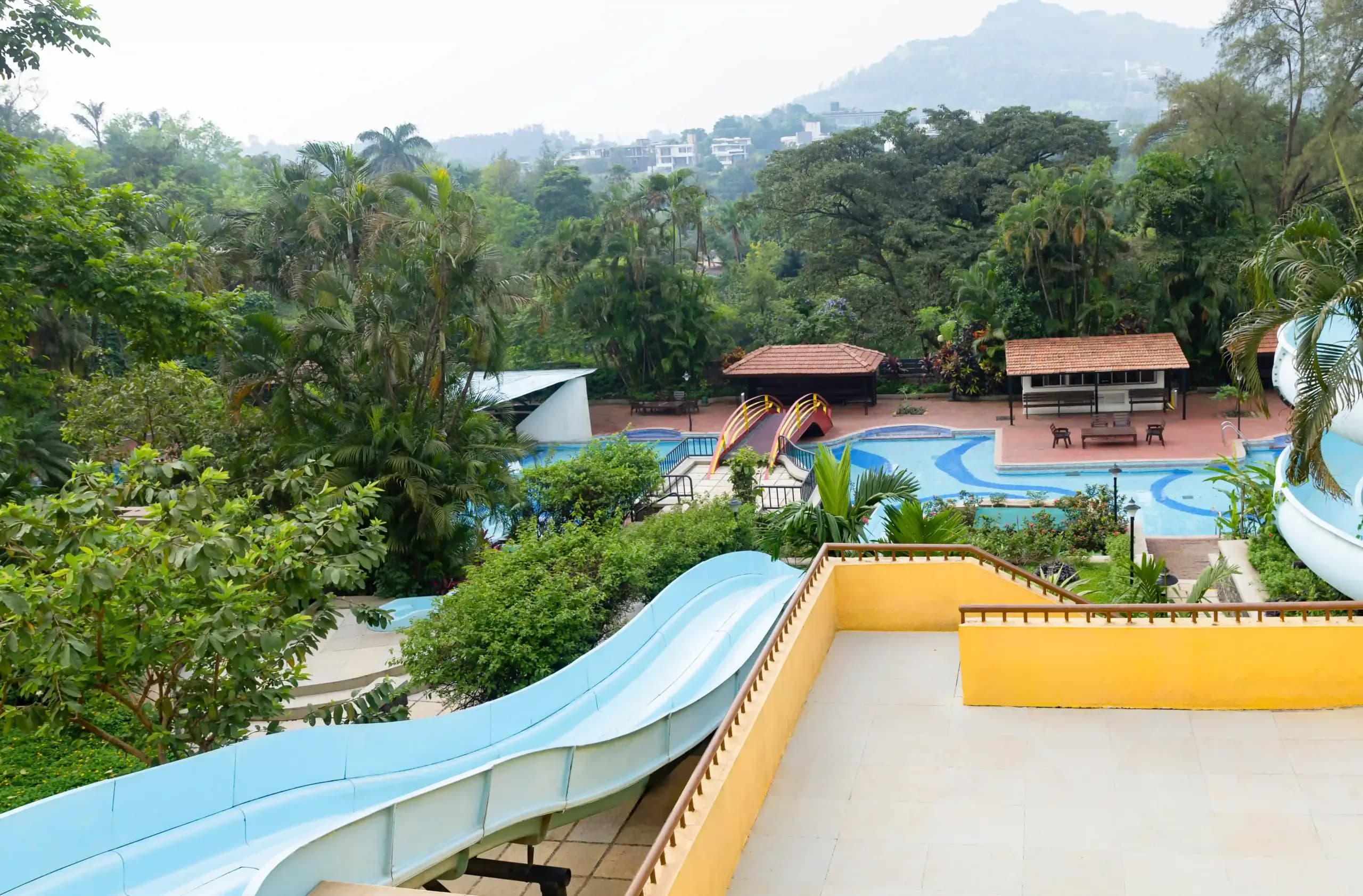 View over the waterpark slides and pools to the green Western Ghats hills at Fariyas Resort Lonavala