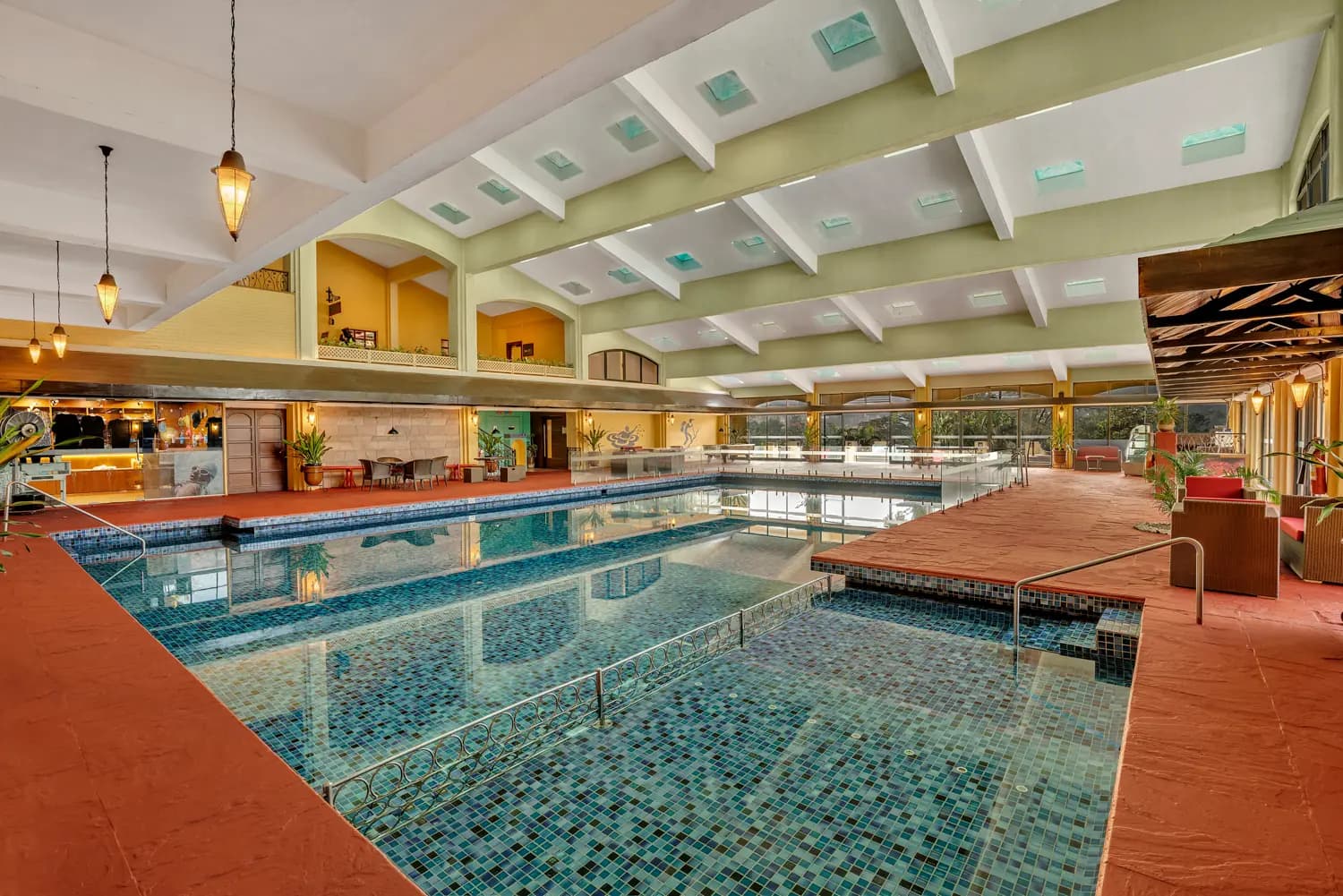 Indoor temperature-controlled swimming pool beneath a high skylit ceiling at Fariyas Resort Lonavala
