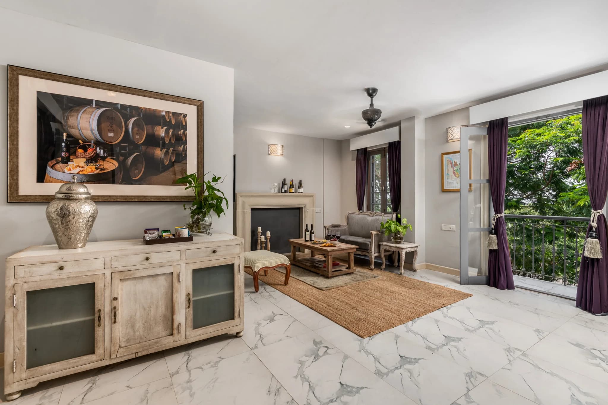 Tower Suite living area with a barrel-room artwork, fireplace corner and balcony at The Source at Sula