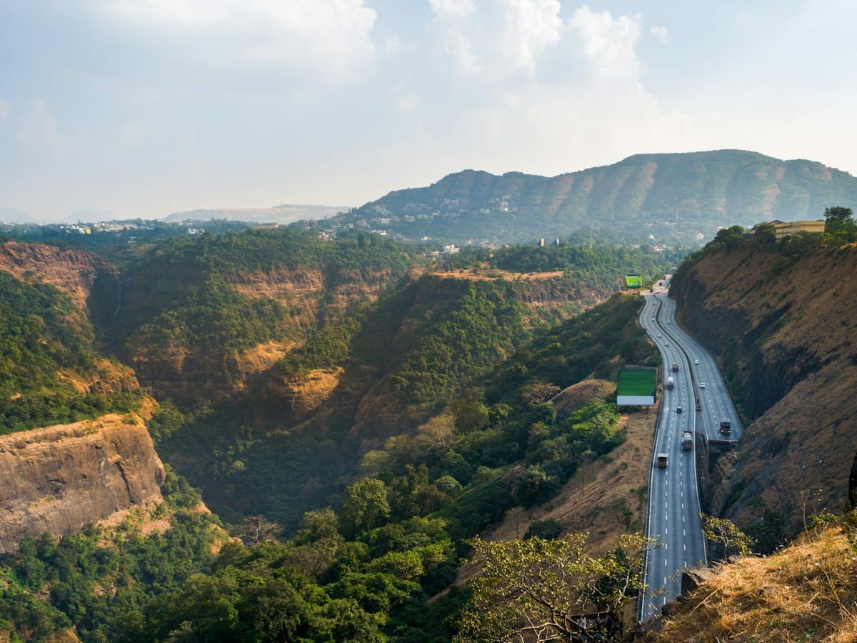 Highway winding through monsoon-green hills seen from Rajmachi Point, Khandala, Maharashtra