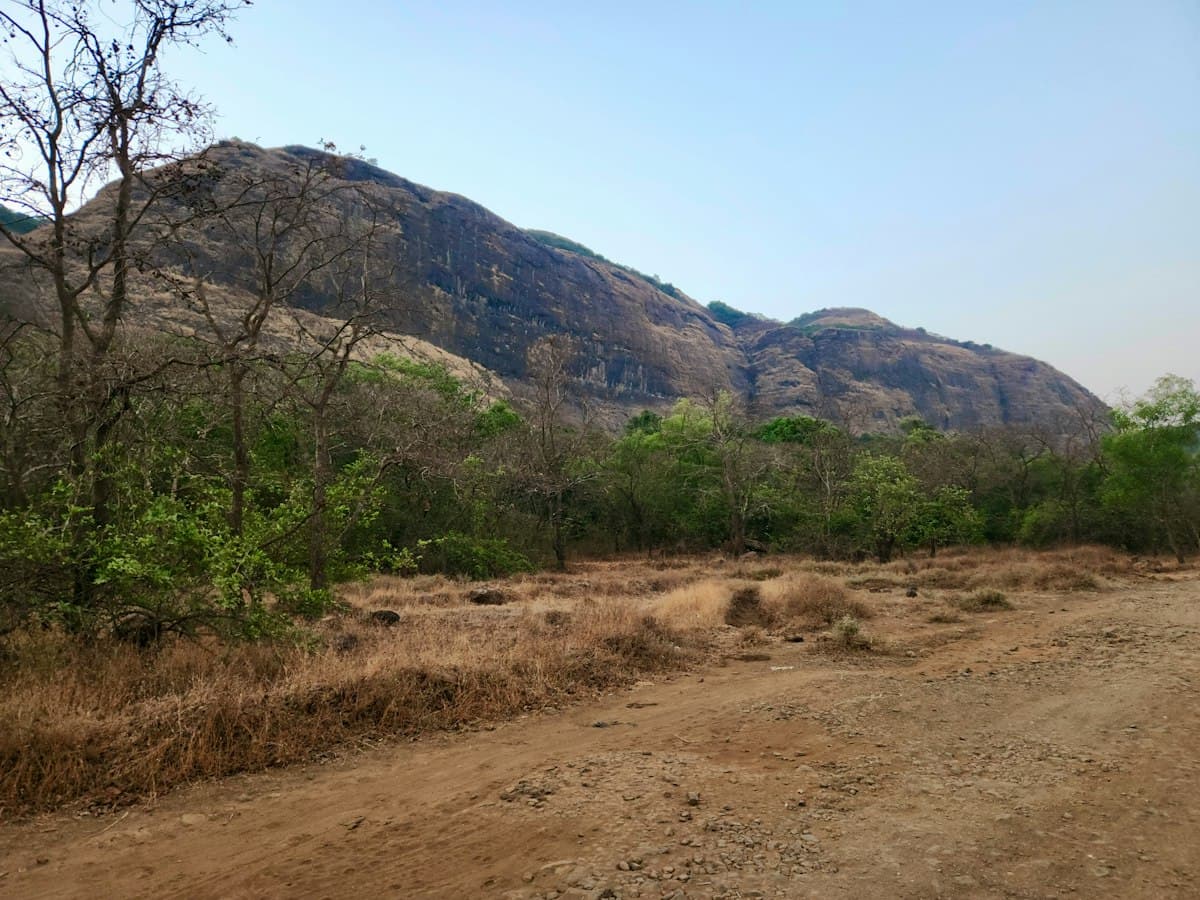 Dirt road below a long Sahyadri mountain face in Khandala, Western Ghats, Maharashtra