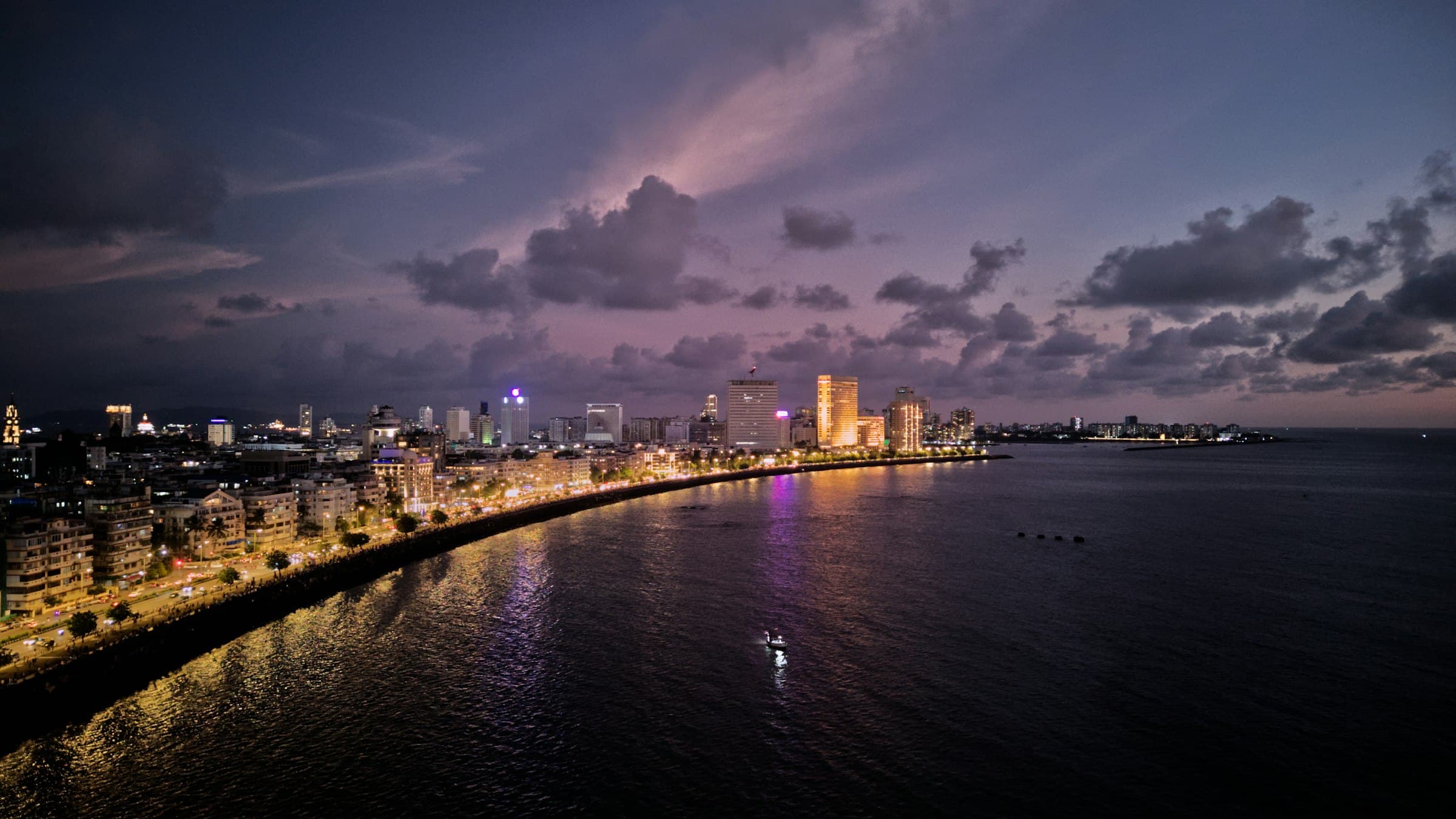 Marine Drive and the Mumbai skyline at dusk across the bay
