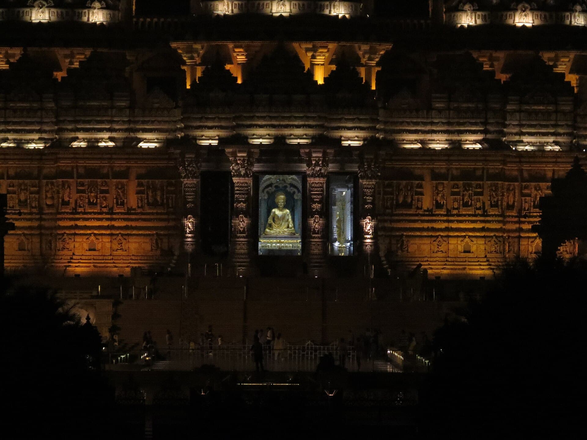 Carved sandstone facade of Swaminarayan Akshardham in Delhi lit at night