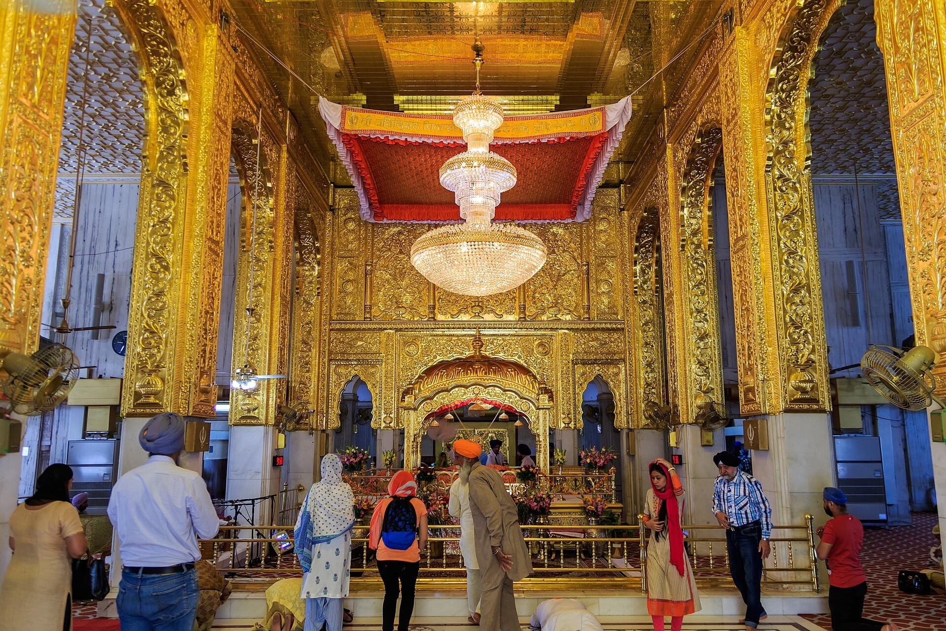 Gilded sanctum hall inside Gurudwara Bangla Sahib, Delhi, with visitors